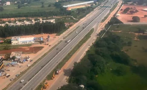 Aerial view of a multi-lane highway with traffic and green surroundings